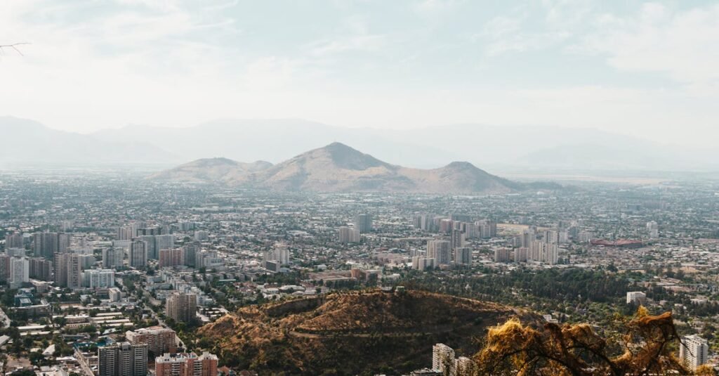Aerial view of Santiago, Chile with mountains in the background and cityscape below.