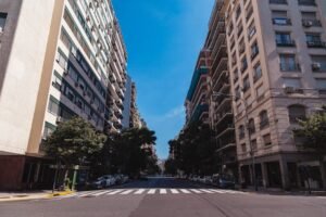 Wide-angle view of a street in Buenos Aires with tall buildings and clear sky.