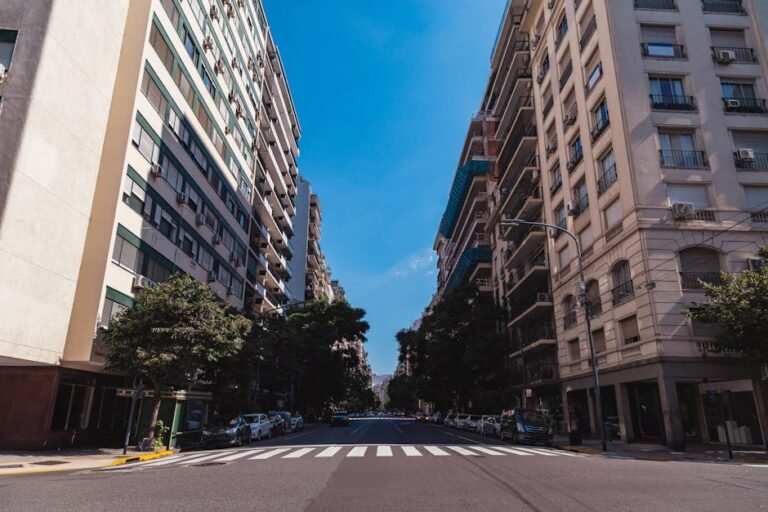 Wide-angle view of a street in Buenos Aires with tall buildings and clear sky.