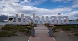 Iconic Ushuaia sign in Argentina with stunning mountain and sea view.