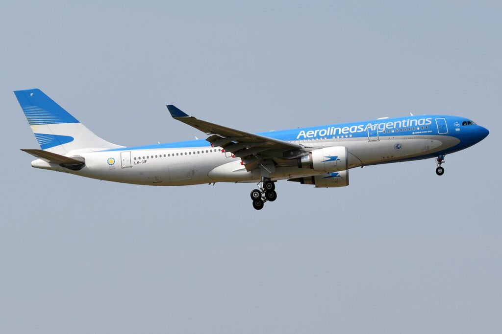 alt: Aerolíneas Argentinas aircraft at the gate in El Calafate, Patagonian steppe in the background