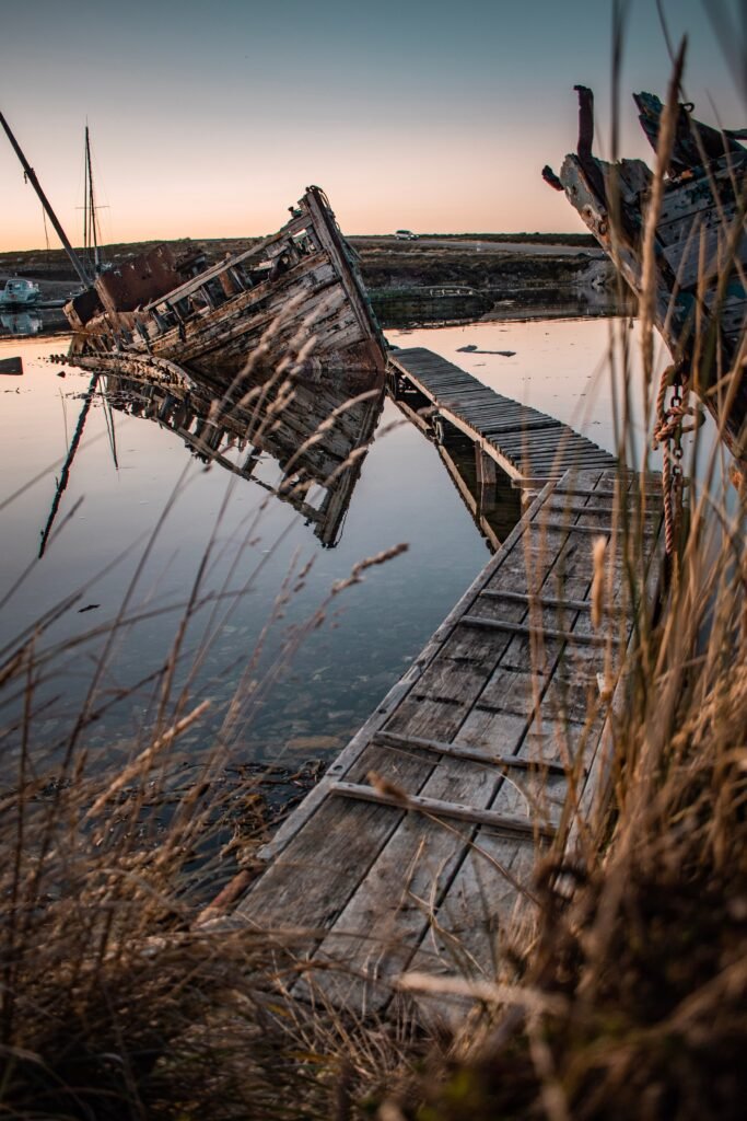A dramatic sunset view of a rusty shipwreck in Stanley, Falkland Islands. Ideal for travel and nature themes.